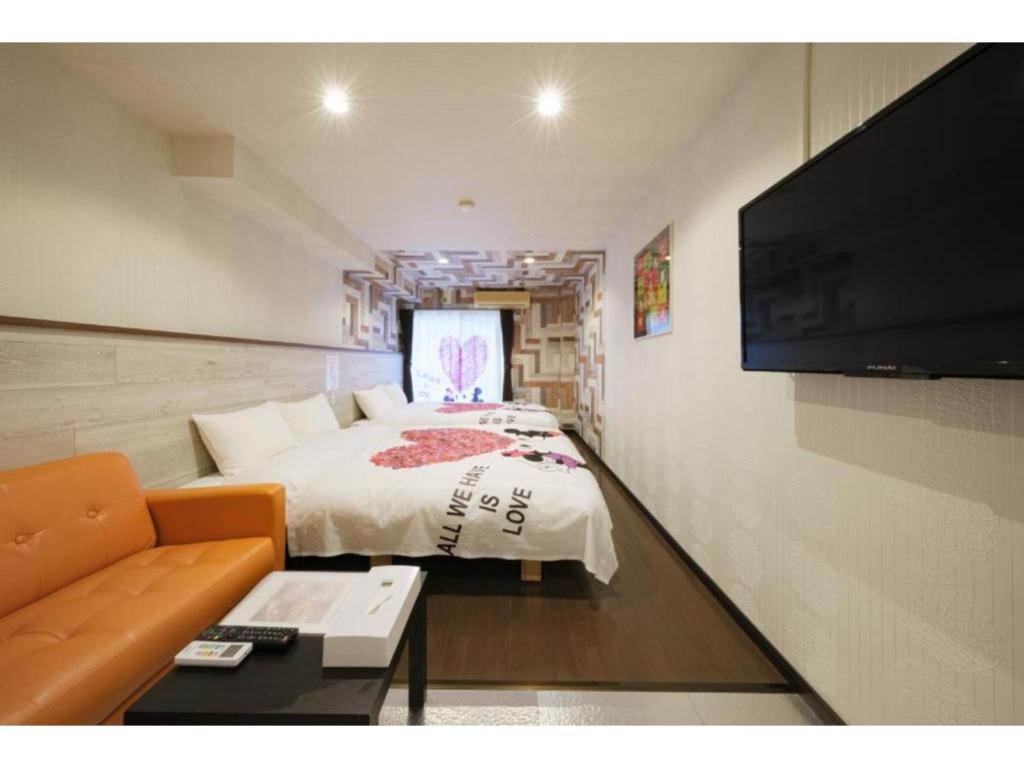 a bedroom with a bed and a flat screen tv at R Hotel - Vacation STAY 19690 in Chiba