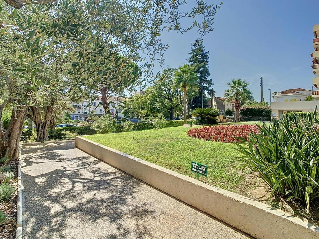 un parc avec un panneau dans l'herbe dans l'établissement Estivalière - 6 couchages - 3 chambre - Parking, au Golfe-Juan