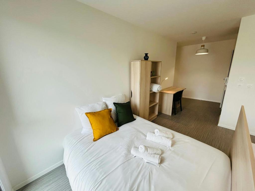 - une chambre dotée d'un lit blanc avec des oreillers jaunes et verts dans l'établissement We Live In R - Suite 403, à Reims