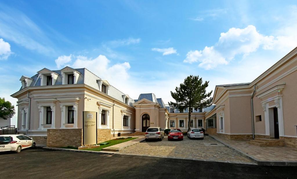 a row of houses with cars parked in a parking lot at Hotel Saint Germain in Brăila