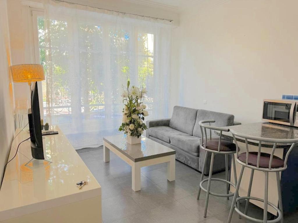 un salon avec un canapé et une table dans l'établissement Charmant 2 pièces 600m plage 1km de la gare, à Nice