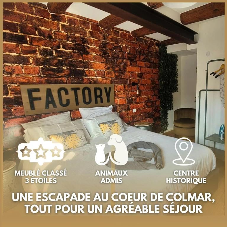 Cette chambre dispose d'un lit avec un mur en briques. dans l'établissement Hyper centre Colmar The Factory Room, à Colmar