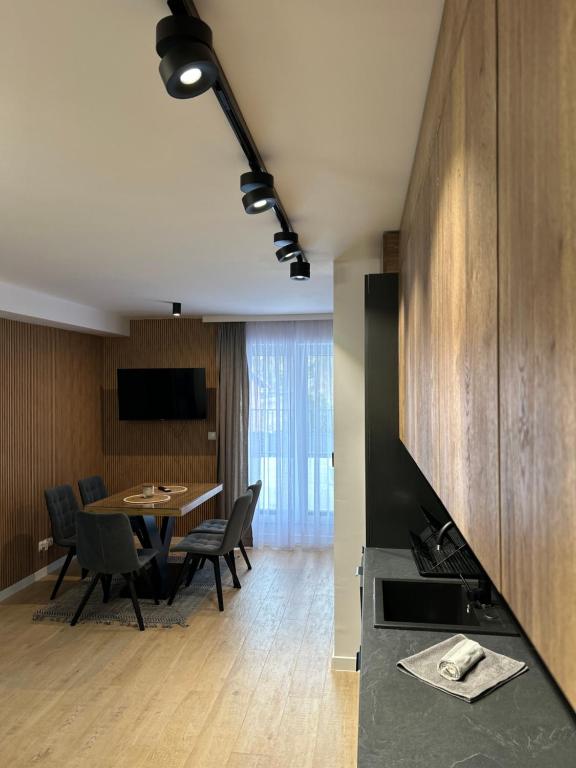科尔别卢夫Leśne Wzgórze Apartamenty的配有桌椅的厨房和餐厅