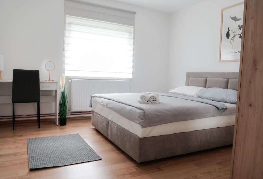 a bedroom with a bed and a desk and a window at Kuća za odmor Marof in Sveti Martin na Muri