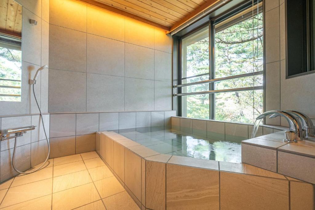 a large bathroom with a tub and a sink at Villa Mille - Vacation STAY 19589 in Ito