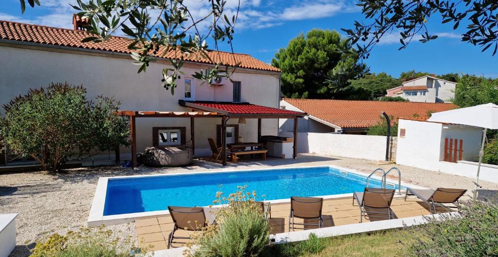 une piscine devant une maison dans l'établissement Villa John, à Pula