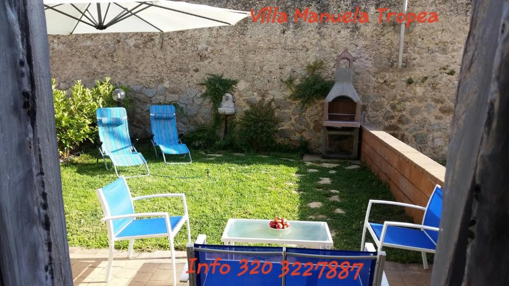 un grupo de sillas y una mesa en un patio en Villa Manuela, en Tropea