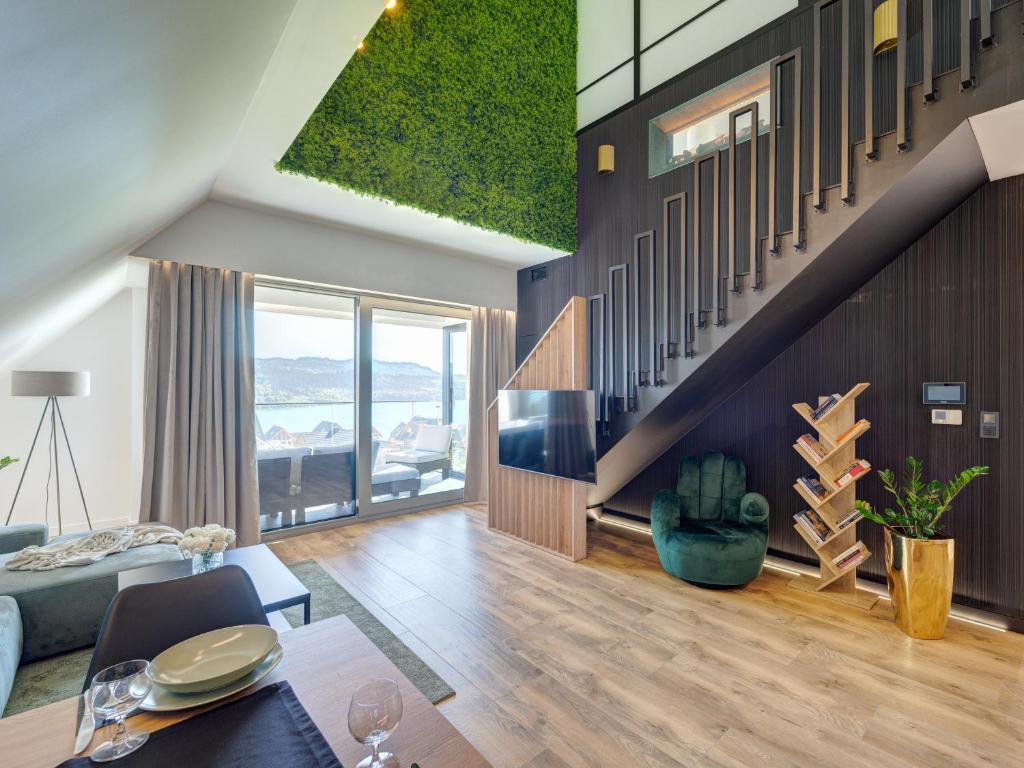 a living room with a staircase and a couch at Apartament Panorama Lake & Ski in Kluszkowce
