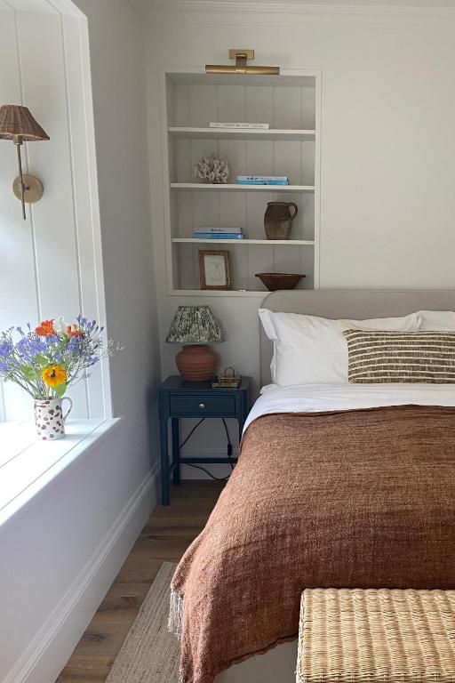 une chambre avec un lit, une fenêtre et une table dans l'établissement Stamping Cottage near Isles of Scilly Park and Ride, à Penzance