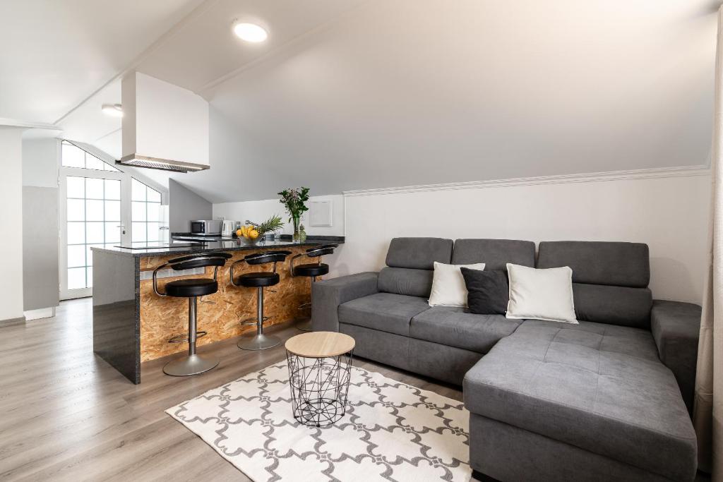 een woonkamer met een bank en een keuken bij Barreiro View in Ribeira Brava