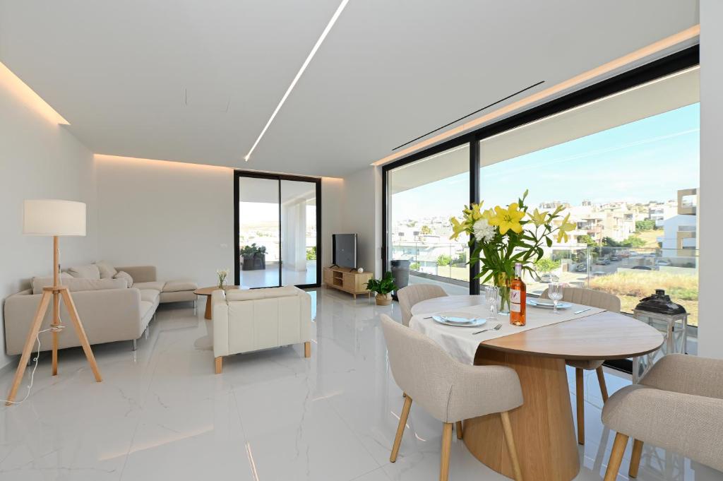 ein Wohnzimmer mit Tisch und Stühlen in der Unterkunft Kalma Luxury Living Suites Heraklion in Iraklio