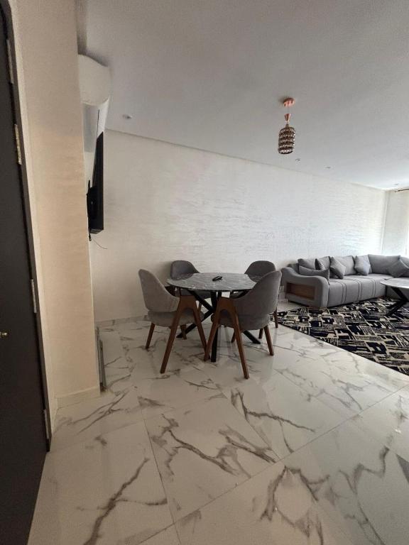a living room with a table and chairs and a couch at Nice apartment in Marrakesh in Marrakesh