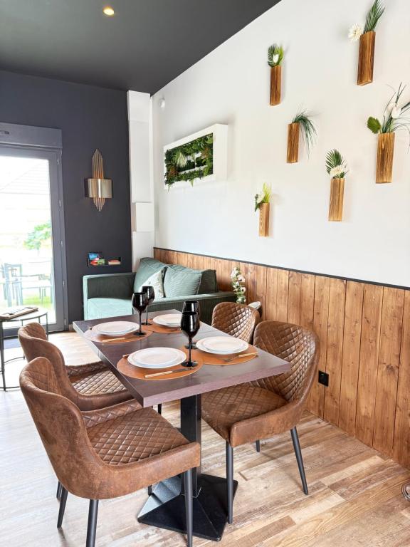 a dining room with a table and chairs at Jardin Secret in Groffliers