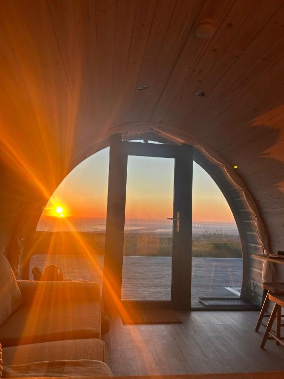 a room with a window with the sunset in the background at Danu Resort in Castlerock