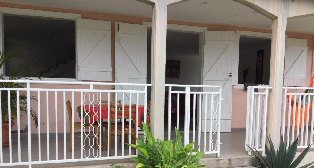 a porch of a house with a white fence at Villa Hibiscus in Bouillante