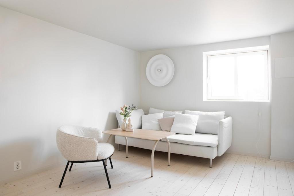 a white living room with a white couch and a table at Ny og moderne leilighet i Bodø Sentrum! in Bodø