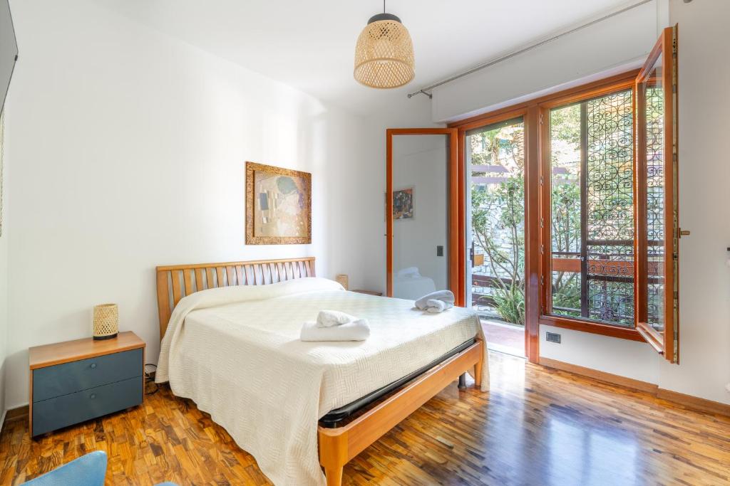 a bedroom with a bed and a large window at Rapallo Charm in green in Rapallo