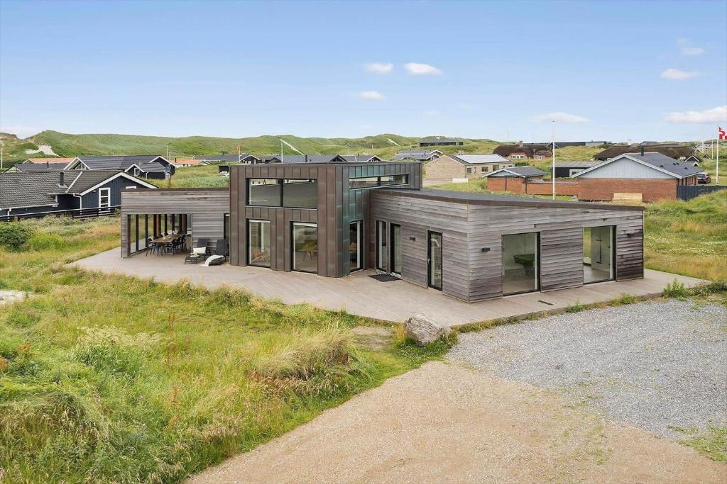 a house in a field with some buildings at 4426-Hvide-sande-Granvej-4 in Hvide Sande