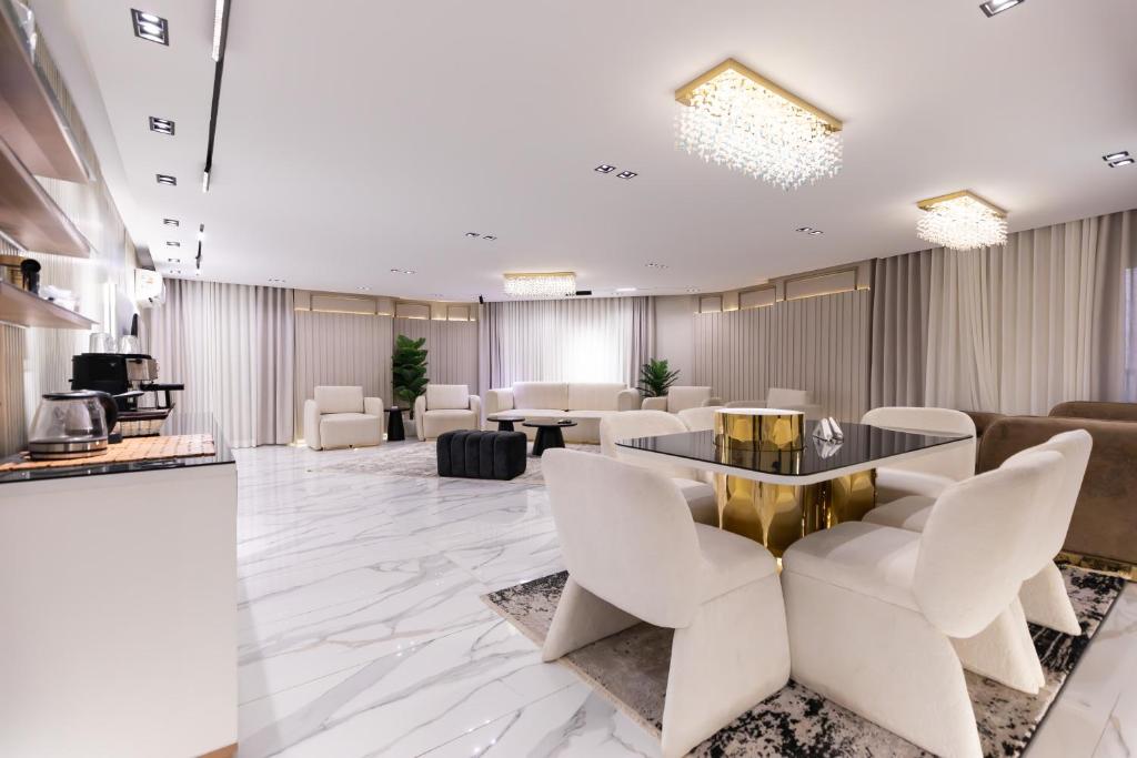 un vestíbulo con sillas blancas y una mesa en Zahir 202, en El Cairo