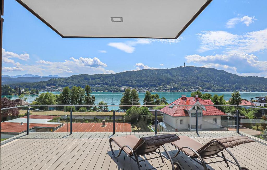 a patio with chairs and a view of the water at Ferienwohnung Pörtschach 110M² in Pörtschach am Wörthersee