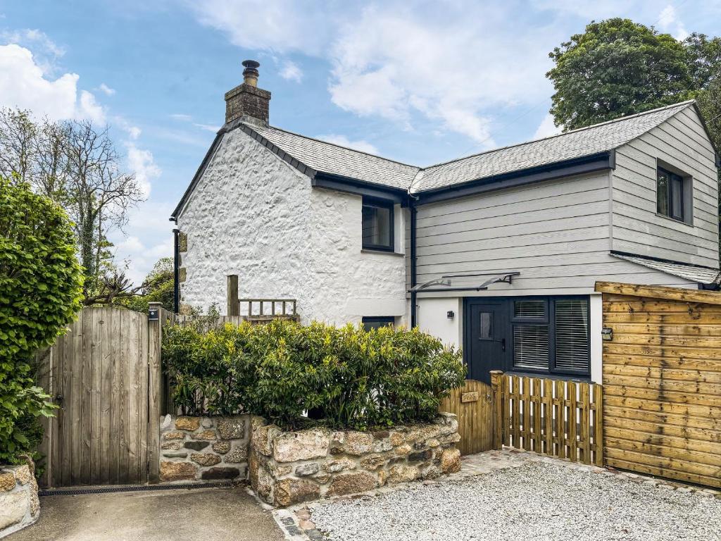 Ce cottage blanc est doté d'une clôture en bois. dans l'établissement The Nest, à Uny Lelant