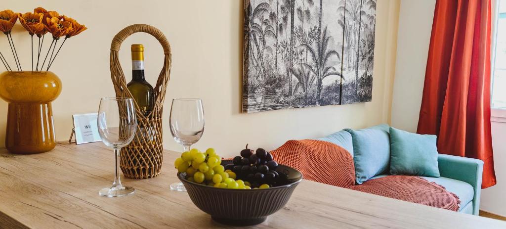 une table avec un bol de raisins et des verres à vin dans l'établissement Theotoki Attic Studio, à Corfou