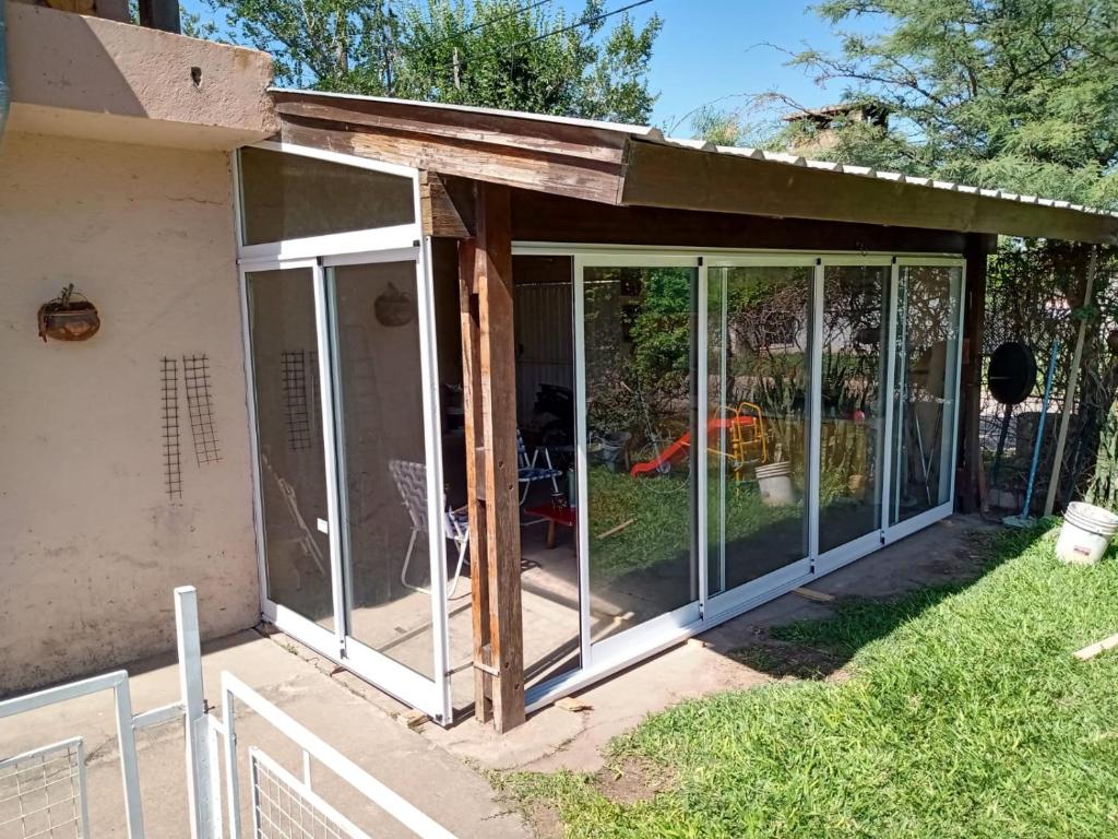 a screened in porch with sliding glass doors at La casita del Malevo in San Francisco