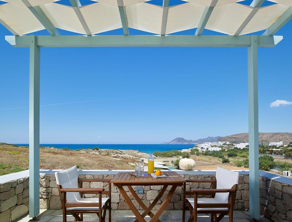 een tafel en stoelen op een patio met uitzicht op de oceaan bij Asterias Boutique Hotel in Pachaina