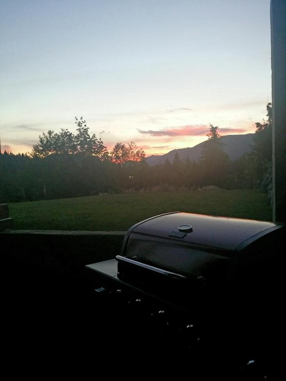 a laptop sitting on a table with the sunset in the background at Cowichan Calling in Lake Cowichan