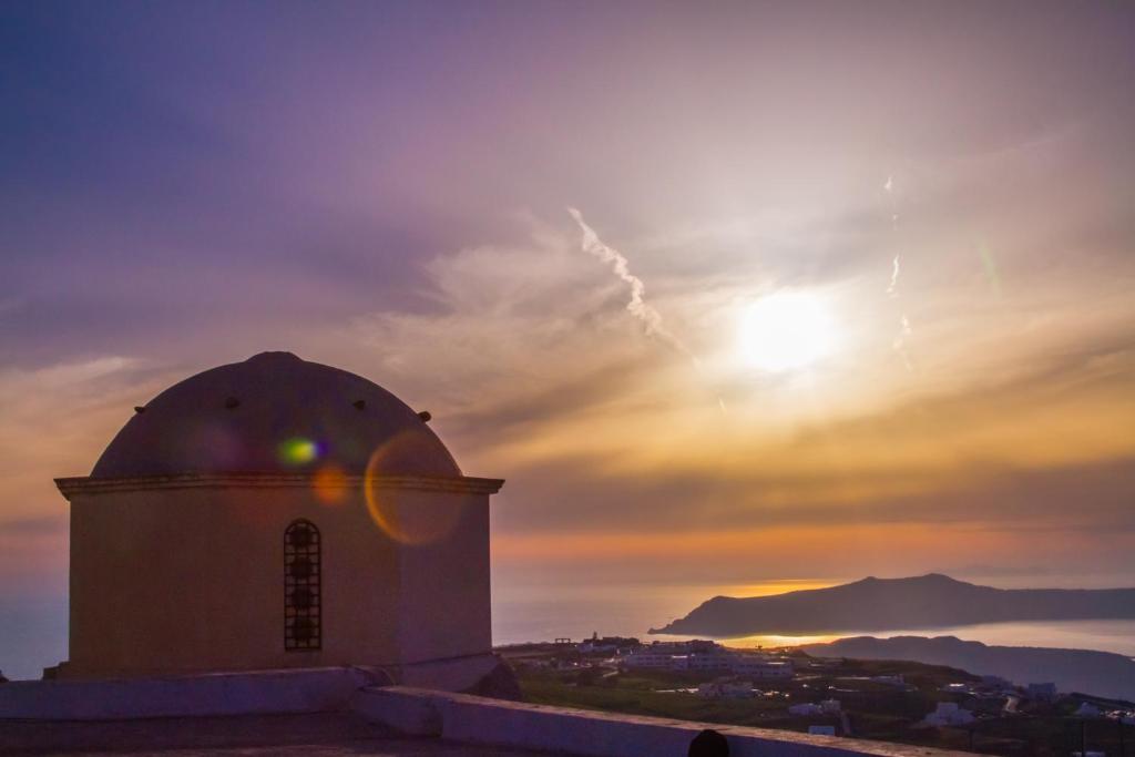 a building with the sunset in the background at Skyline Villa in Pyrgos