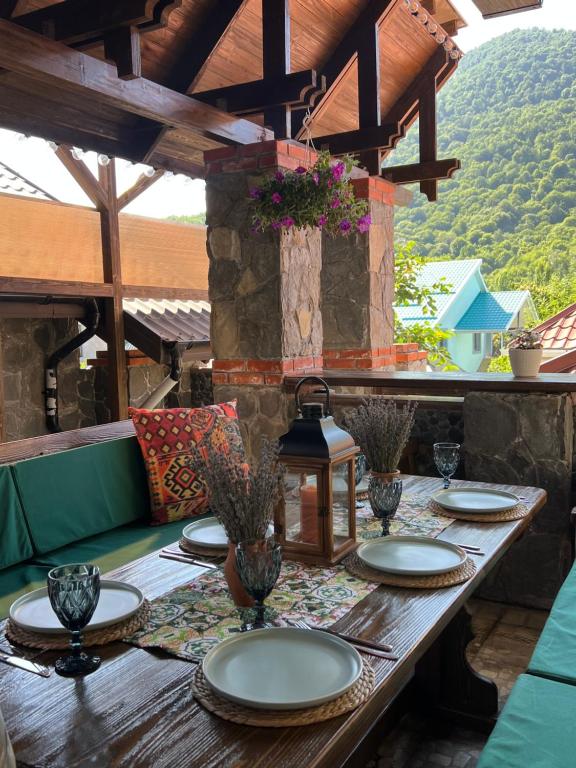 a wooden table with plates on it on a patio at QahramanoffsChalet in Gabala