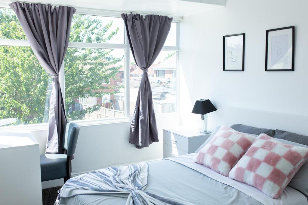 a bedroom with a bed and a large window at An entire 3 Bedroom house in Beeston United Kingdom in Beeston