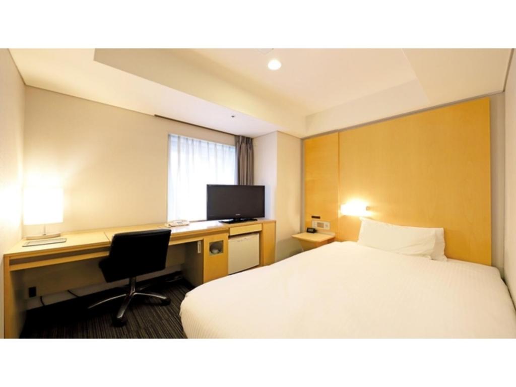 ein Hotelzimmer mit Bett und Schreibtisch in der Unterkunft Smile Hotel Osaka Yotsubashi - Vacation STAY 73524v in Osaka