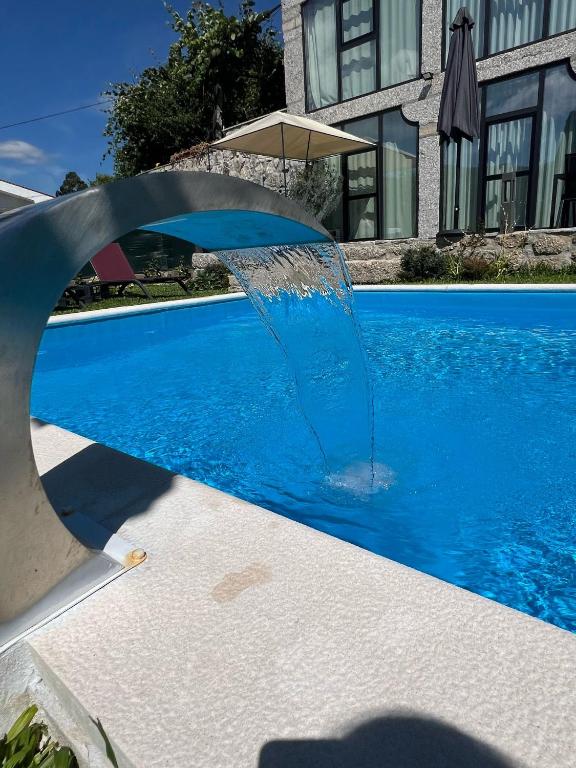 a water fountain in the middle of a swimming pool at Sequeira Arantes Casa 2 in Terras de Bouro