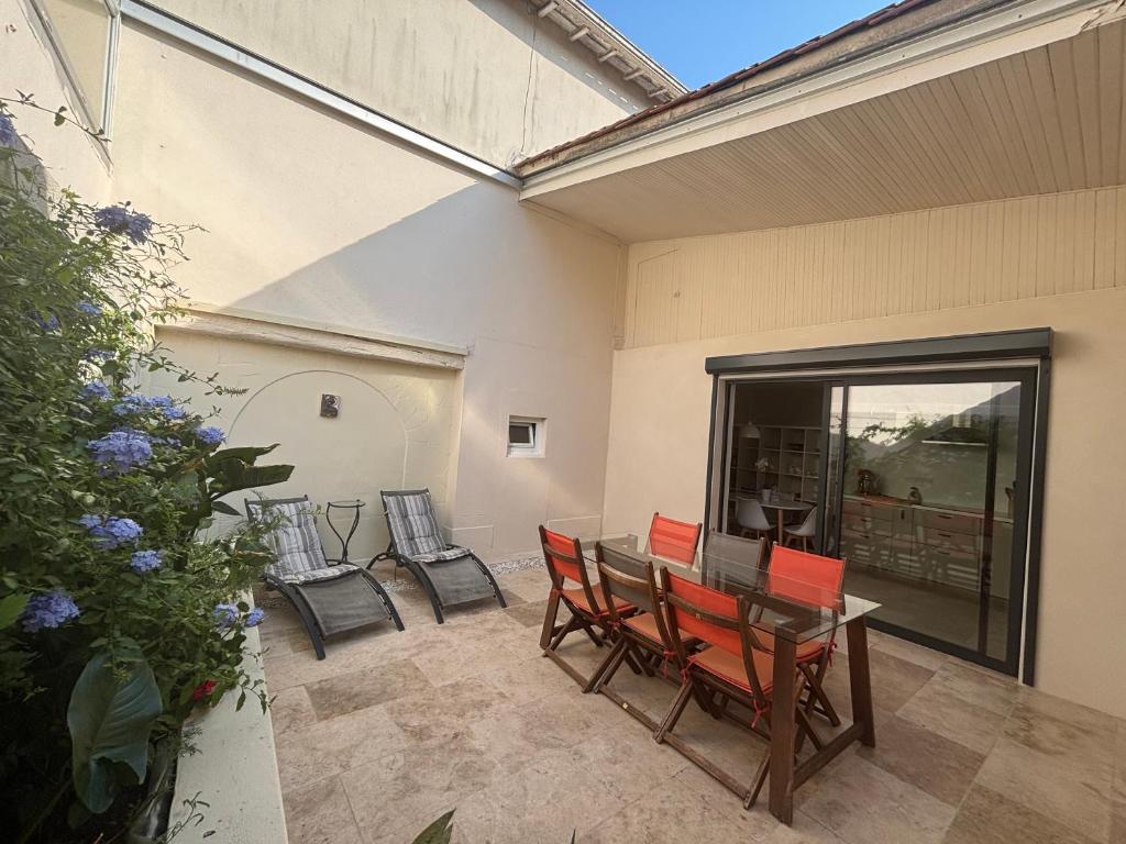 d'une terrasse avec des chaises rouges, une table et une fenêtre. dans l'établissement The Courtyard, Cognac, à Cognac
