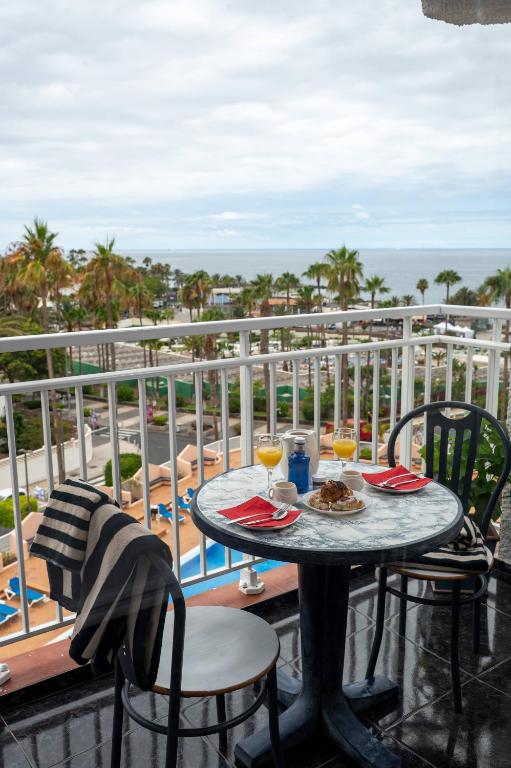 a table on a balcony with a view of the ocean at Juanvi's Corner in Costa de Adeje