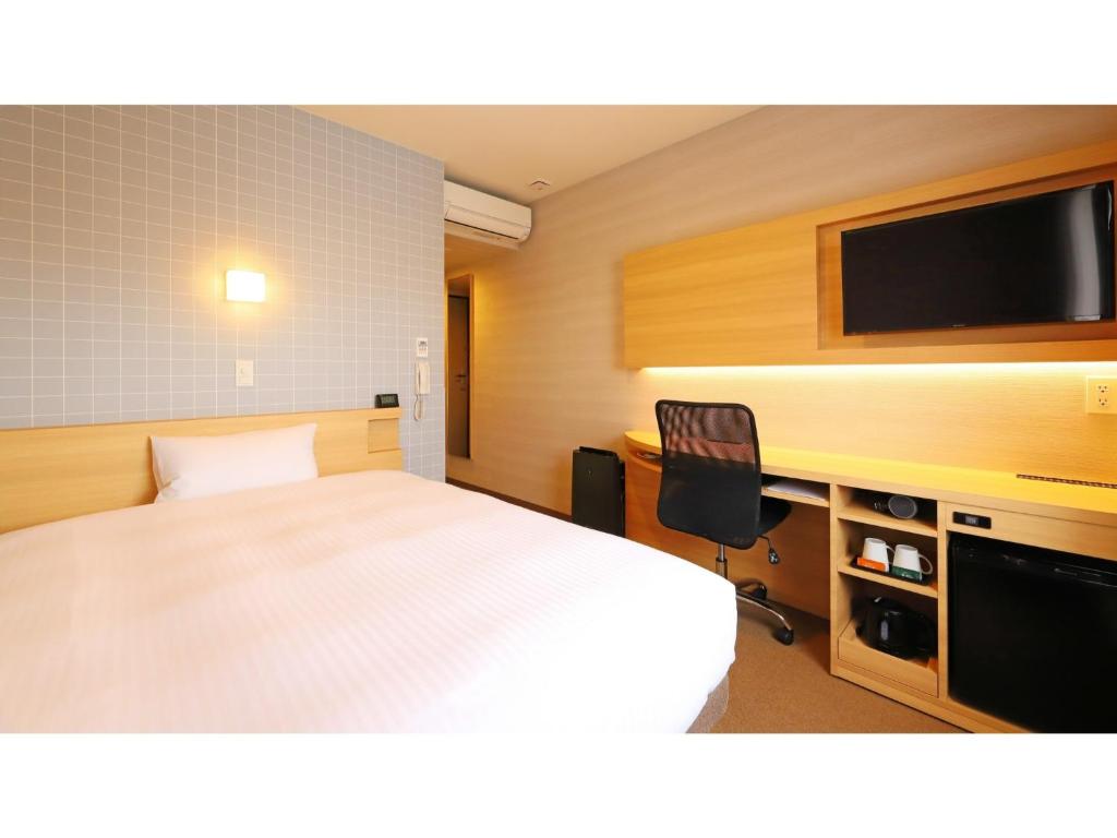 藤沢市にあるSmile Hotel Shonan Fujisawa - Vacation STAY 74516vのベッドルーム(ベッド1台、テレビ、椅子付)