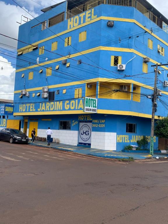 a blue hotel on the side of a street at Hotel Jardim Goiás in Rio Verde