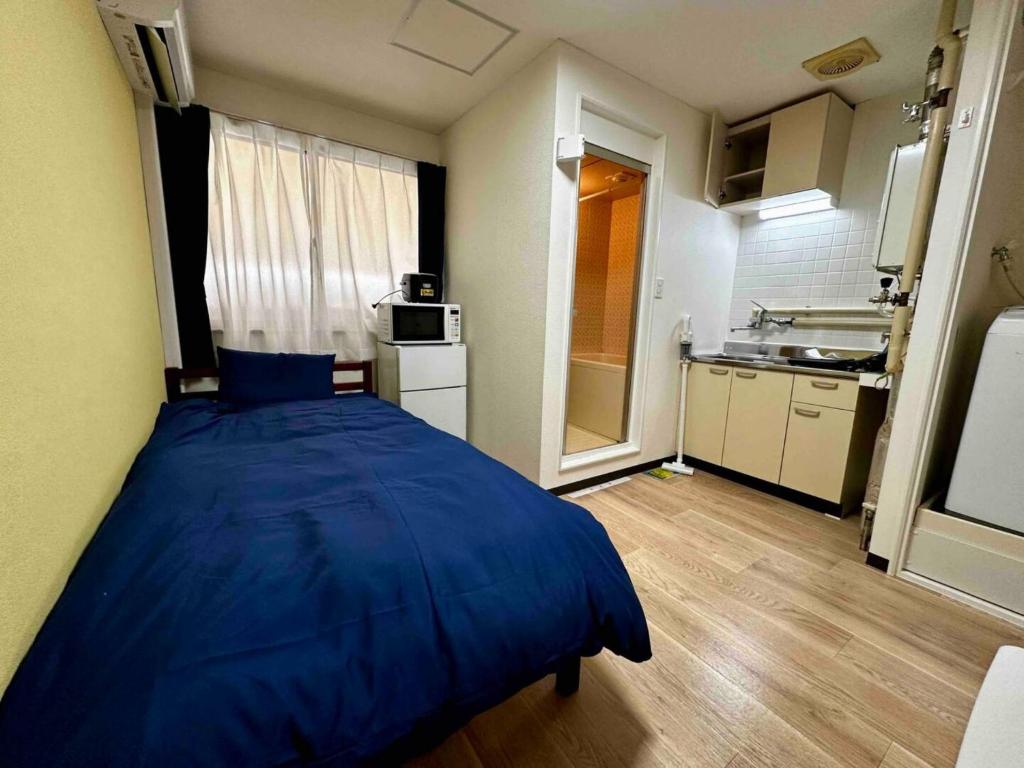 札幌市にあるSky Heights - Vacation STAY 19630のキッチン付きの小さな部屋にある大きな青いベッド