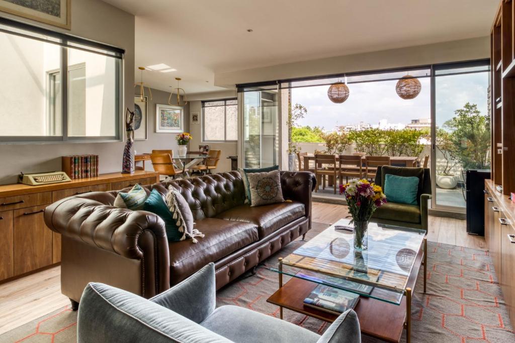 a living room with a leather couch and a glass table at ZAMORA By Mr W in Mexico City