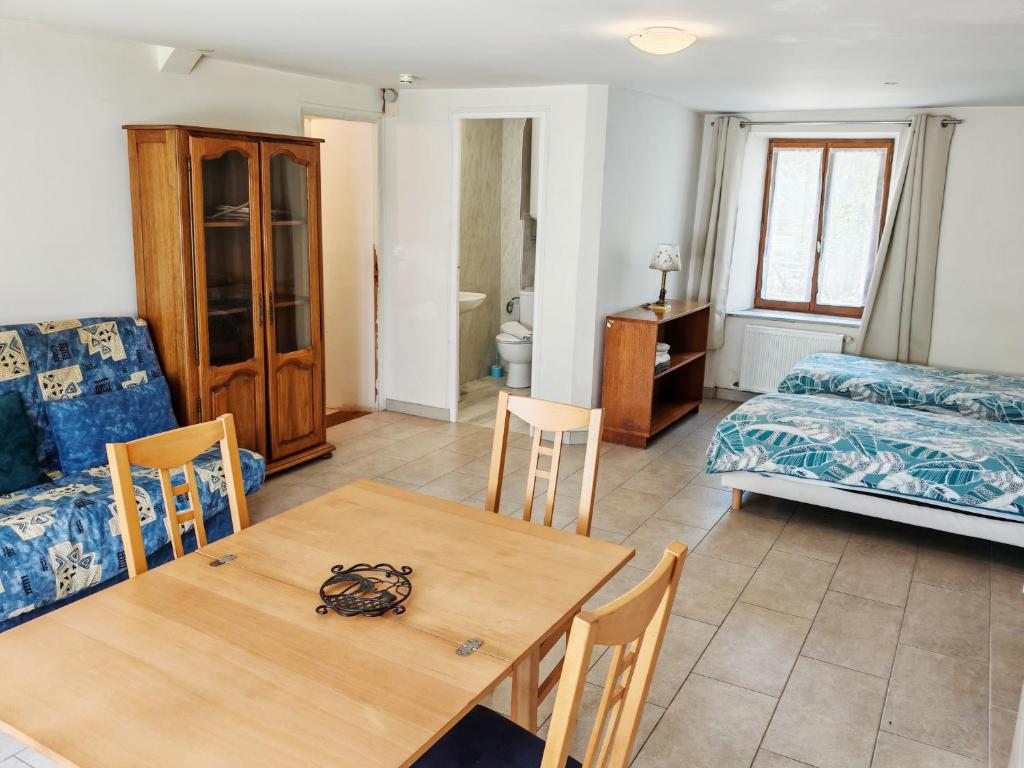 a living room with a table and a bed at La Ferme des Acacias in Ormoy-la-Rivière