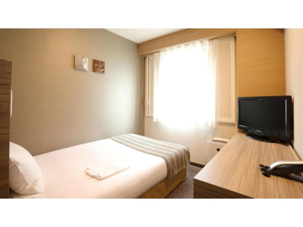 川口市にあるSmile Hotel Kawaguchi - Vacation STAY 76790vのベッドと薄型テレビがあるホテルの部屋