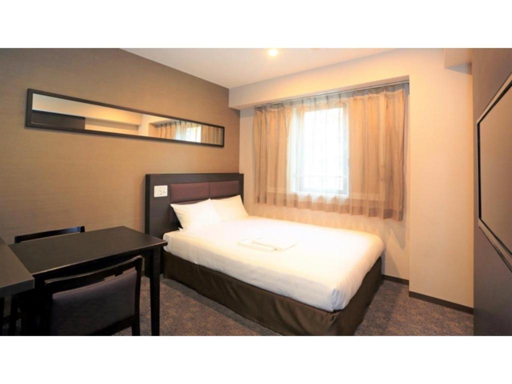 川口市にあるSmile Hotel Kawaguchi - Vacation STAY 76841vのベッドと机と窓のある寝室