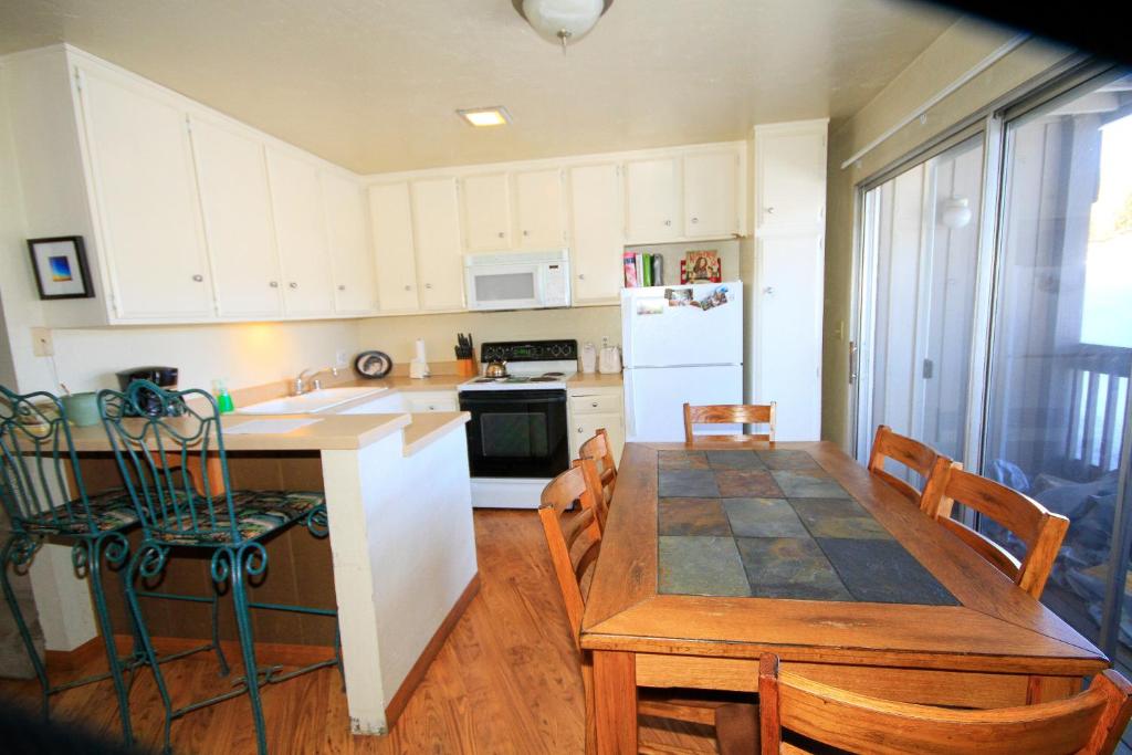 Una cocina y un comedor con mesa y sillas. en Sierra Park Villas #16, en Mammoth Lakes