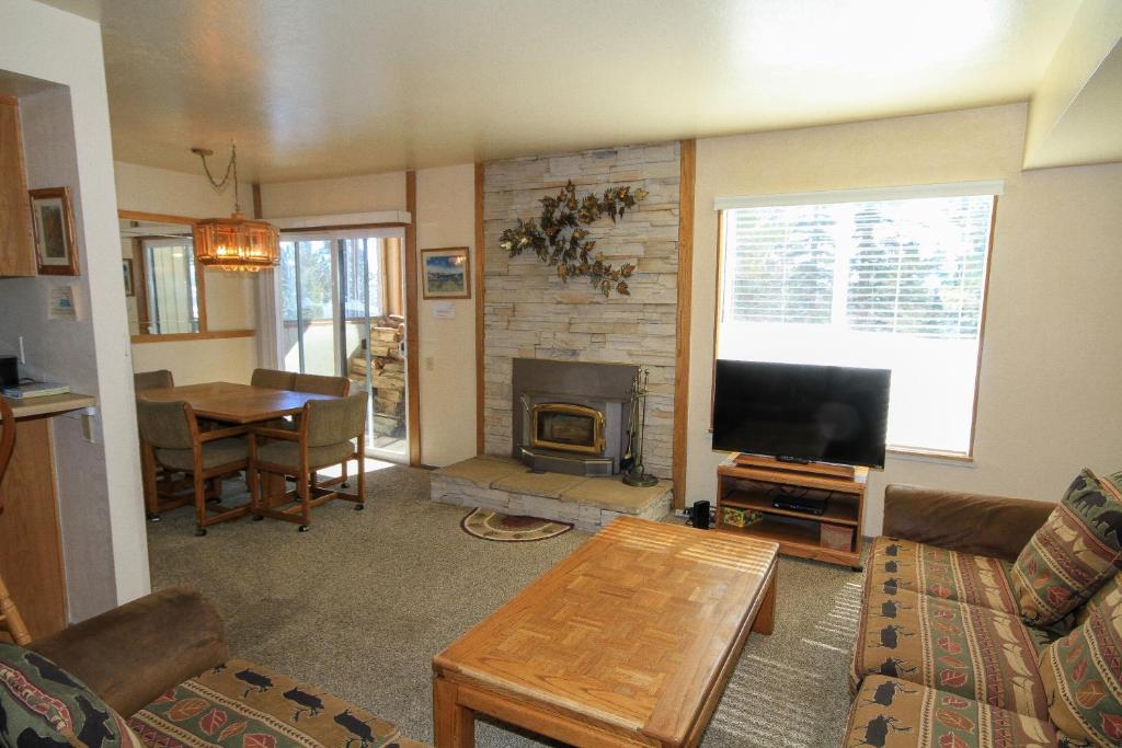 Una sala de estar con un sofá, un televisor y una mesa. en Discovery 4 #125, en Mammoth Lakes