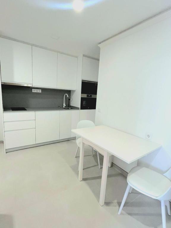 a white kitchen with a white table and chairs at Alondras Luxury Paradise fully renovated in Arona