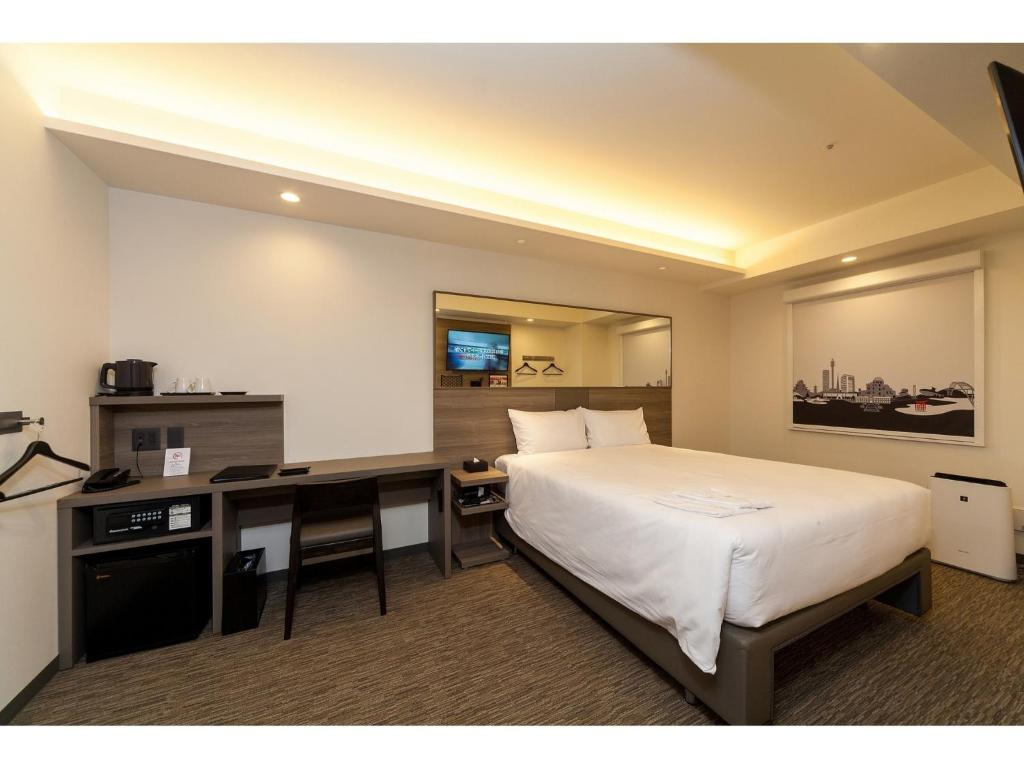 a hotel room with a bed and a desk at Smile Hotel Hiroshima - Vacation STAY 77672v in Hiroshima