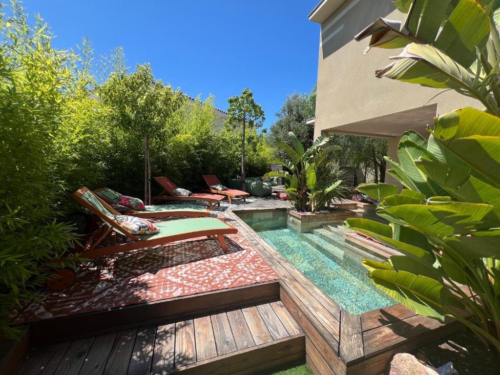 une cour arrière avec une piscine avec une terrasse et des chaises dans l'établissement L'Oasis Secrète de la Corniche, à Sète