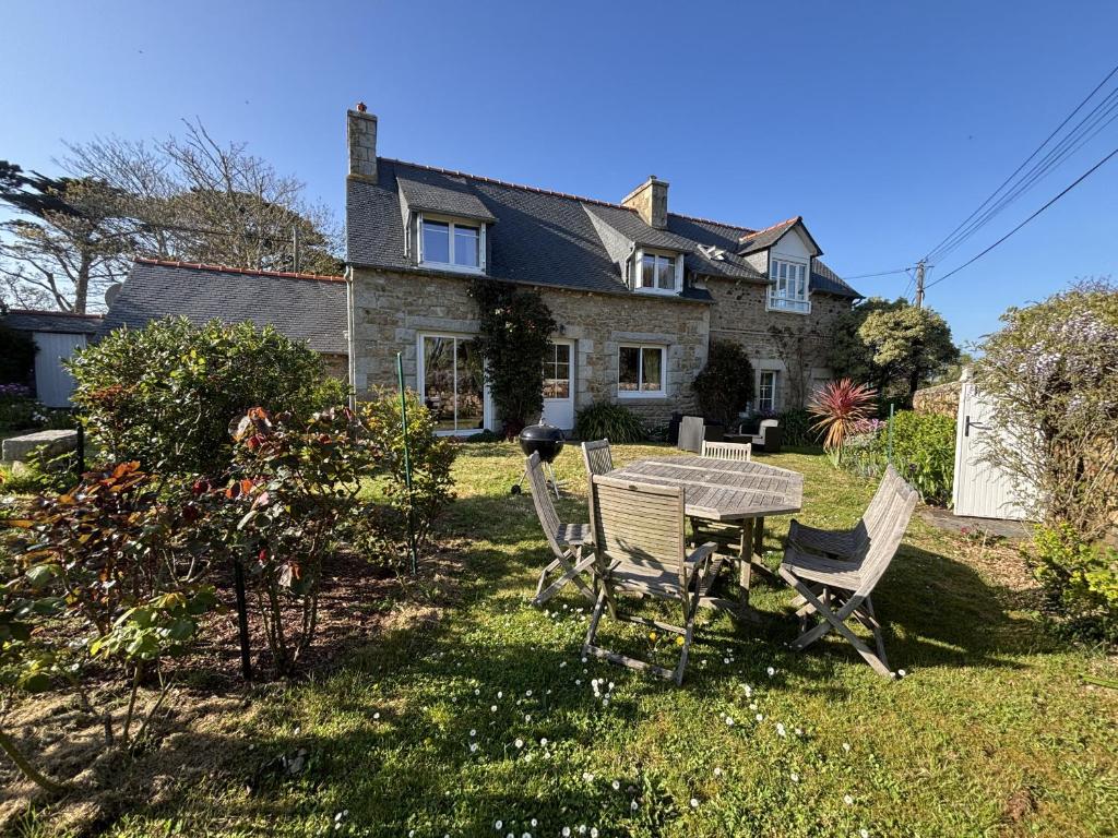 une maison avec une table et des chaises dans la cour dans l'établissement Ty Moune proche mer, à Penvénan