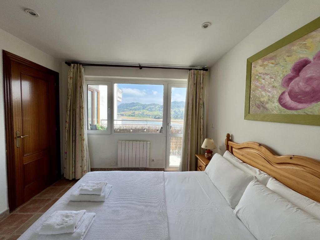 een slaapkamer met een groot bed en een groot raam bij La Ria - by Wehomes - Mogro River in Miengo